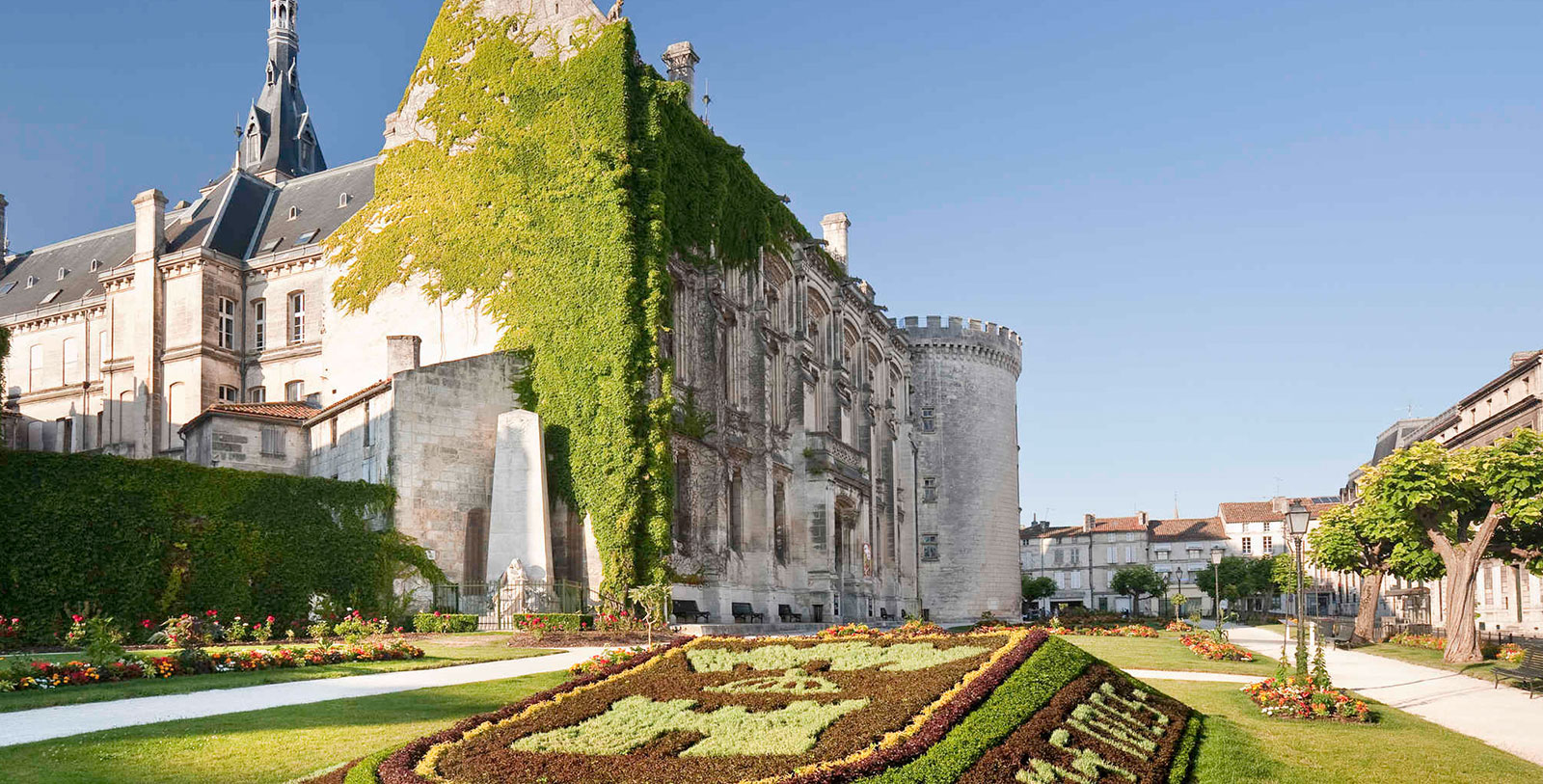 a large stone building with a garden in front of it