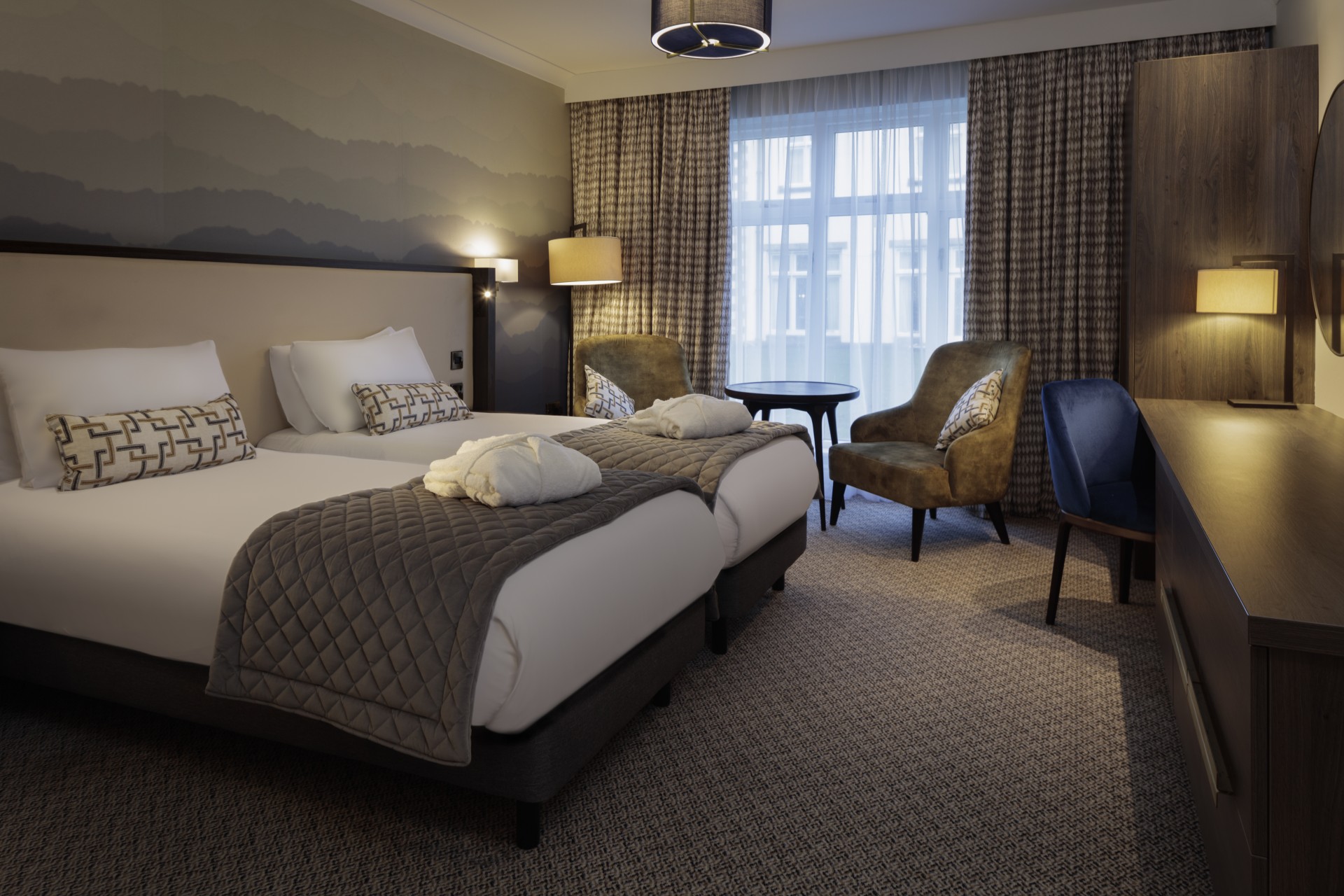a hotel room with two beds and chairs