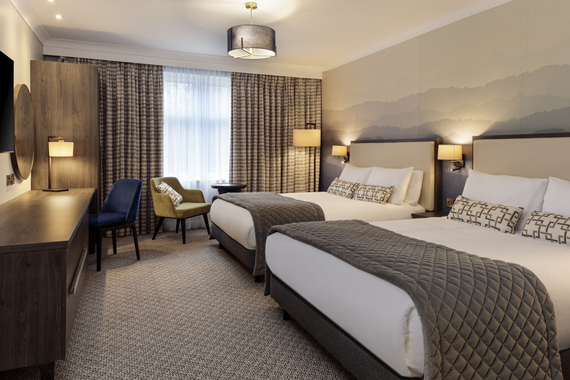 a room with two beds and a chair