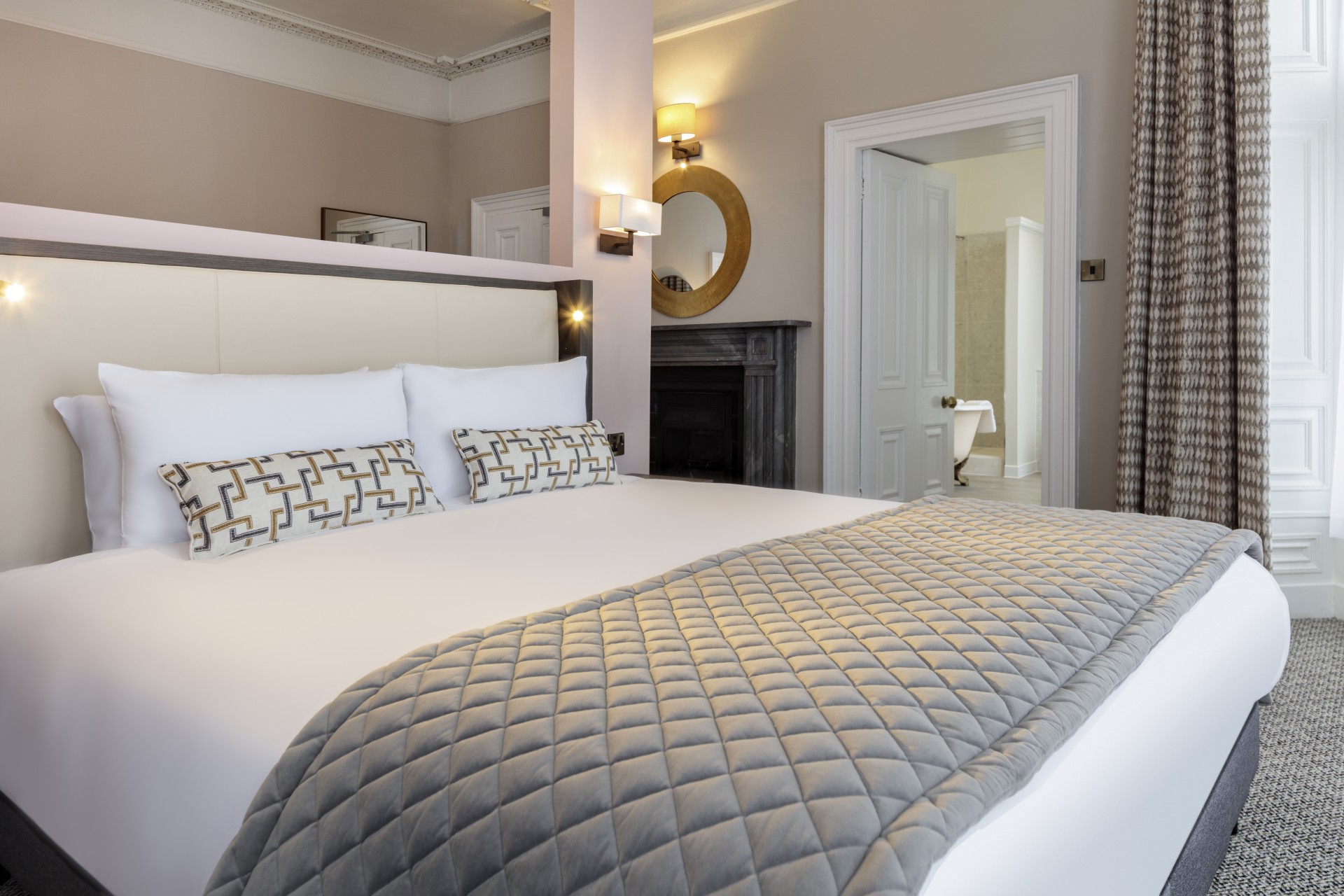 a bed with pillows and a mirror in a room
