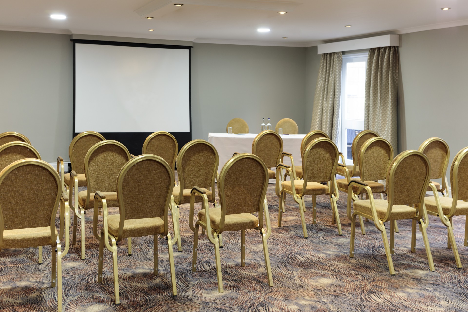 a room with chairs and a projector screen
