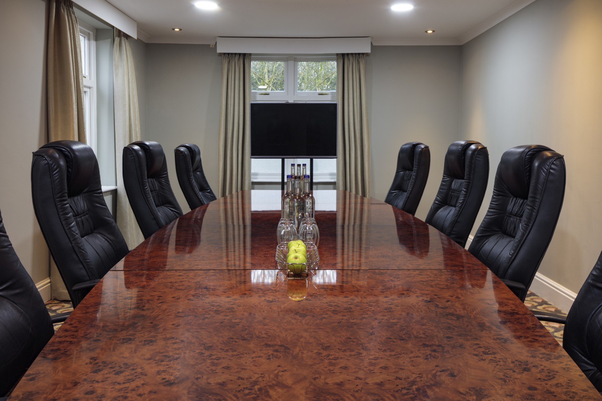 a conference table with chairs and a television