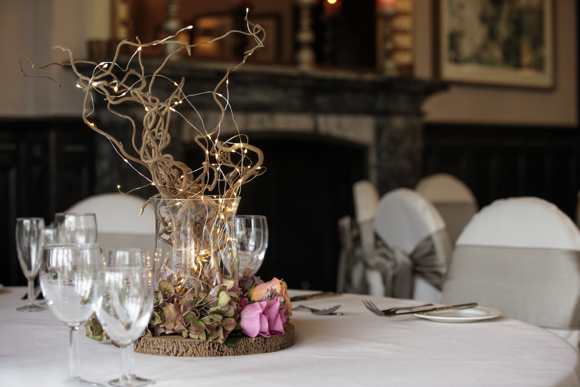 a table set with wine glasses and a vase with flowers