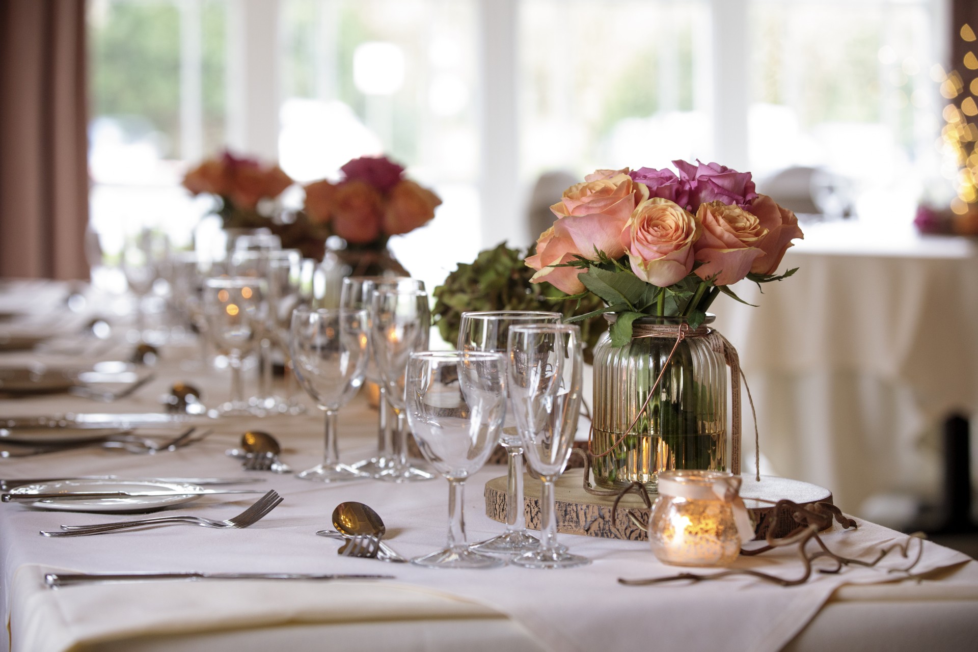 a table with wine glasses and flowers
