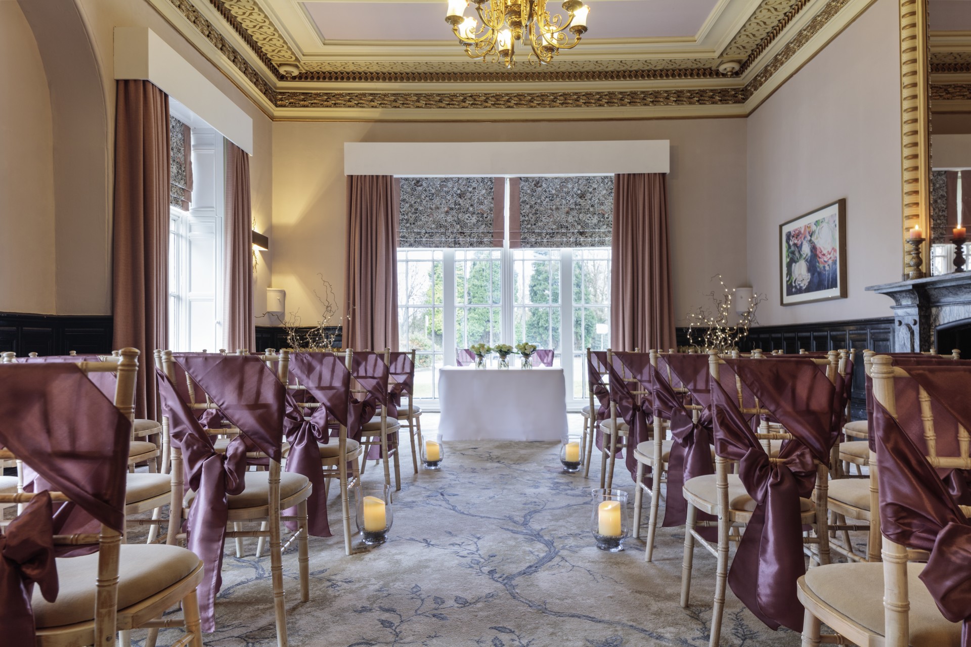 a room with chairs and tables with purple sashes