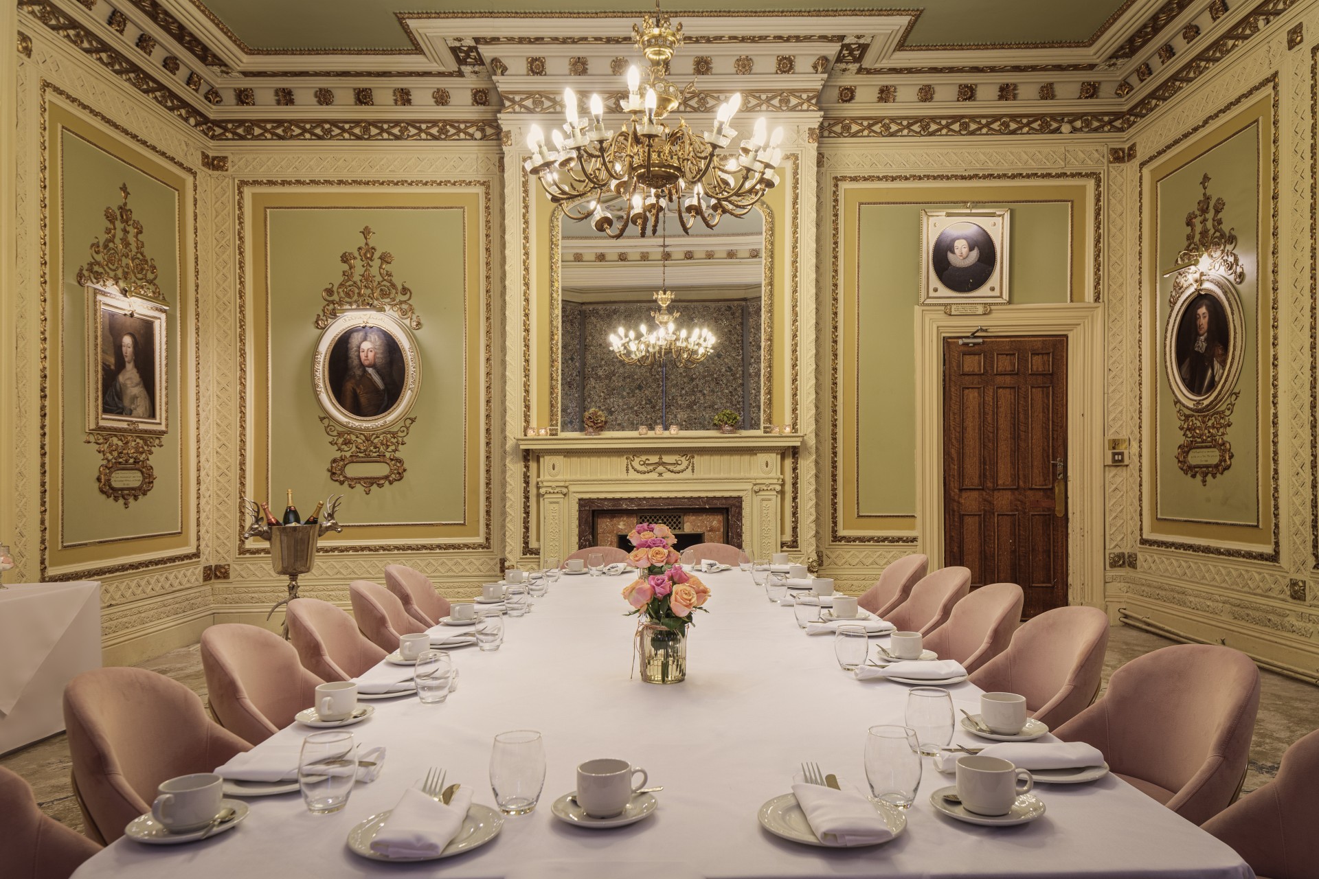 a large dining room with a chandelier and a table set with plates and glasses