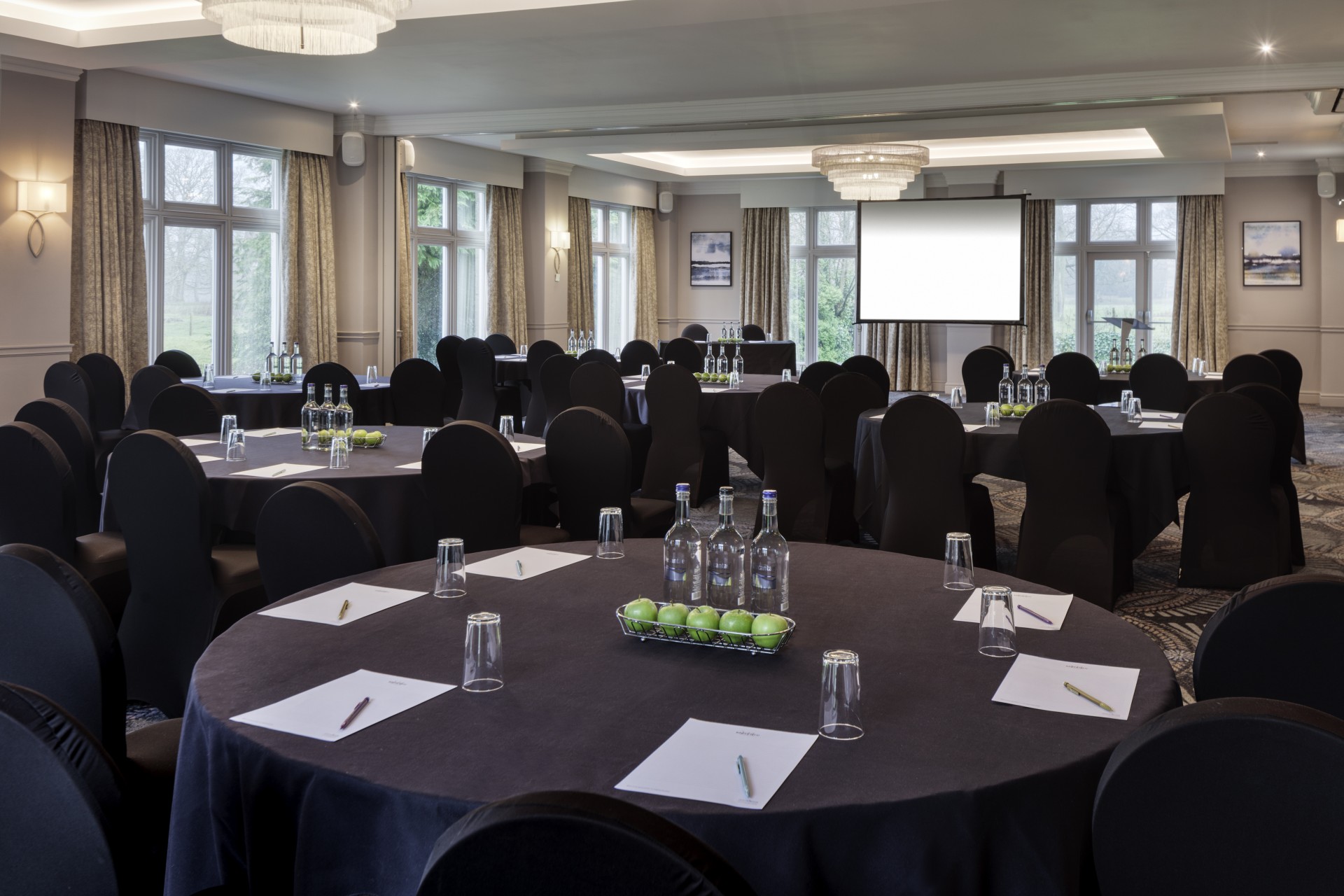 a room with round tables and black chairs