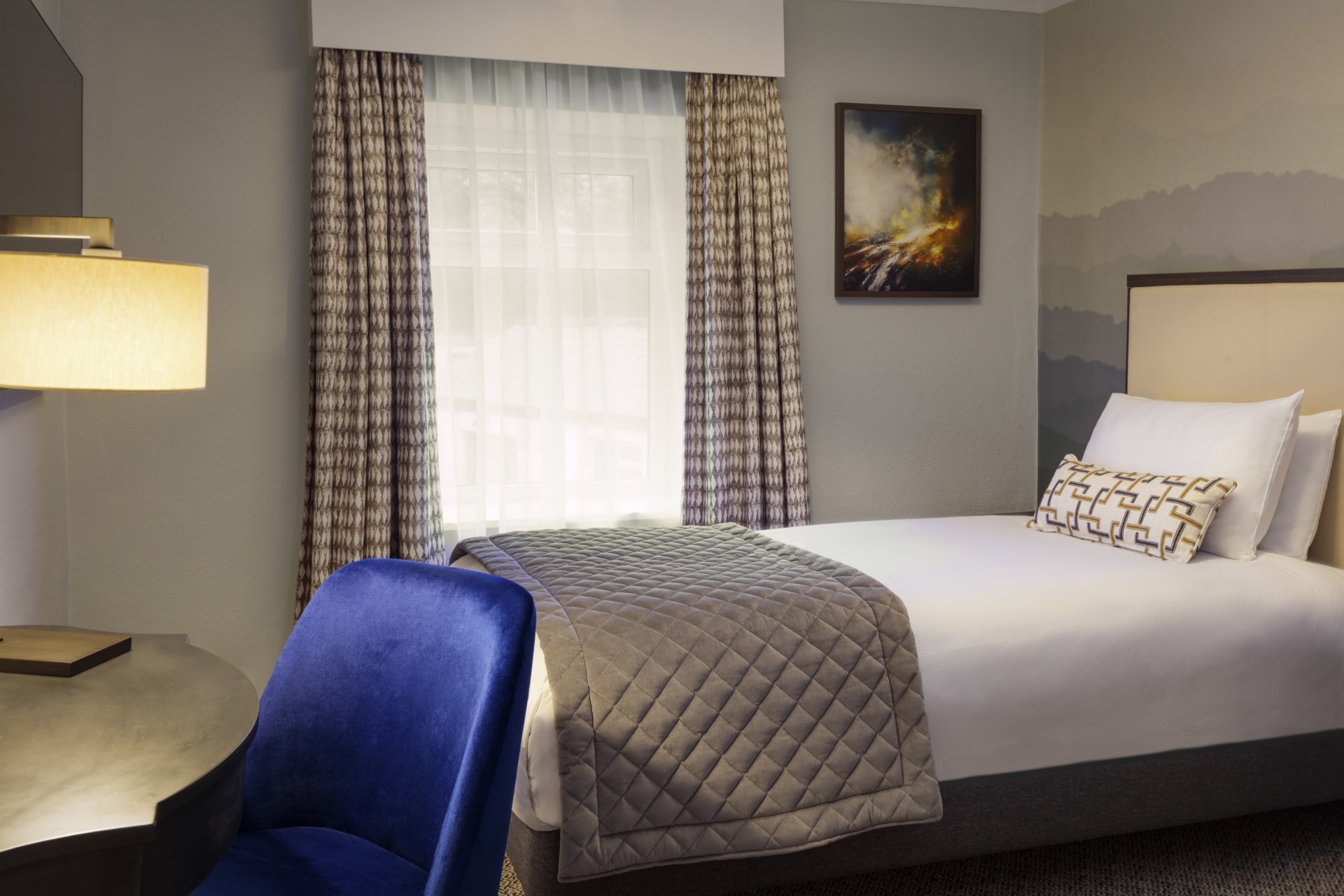 a bed with a blue chair and a table in a room
