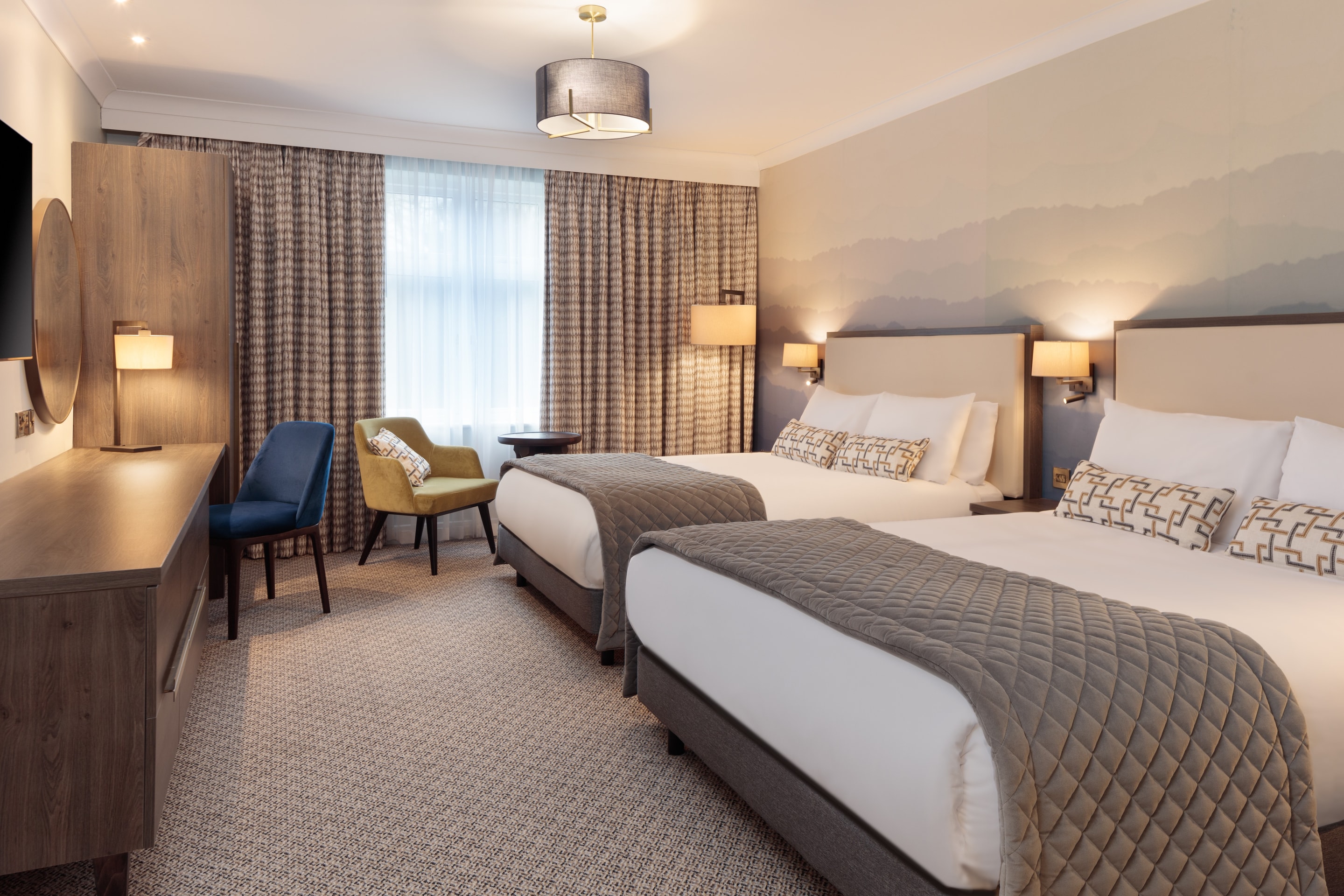 a room with two beds and a chair