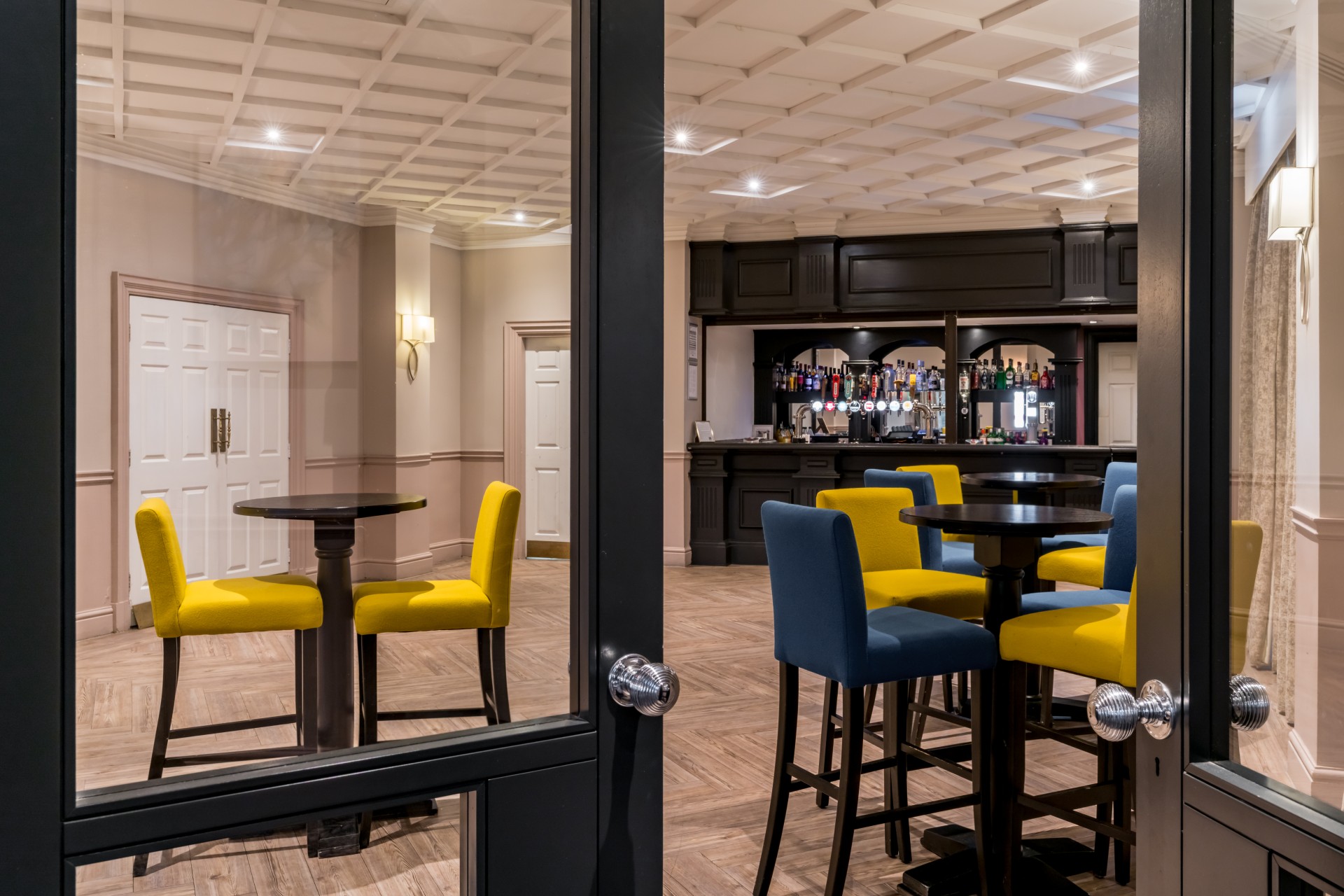 a room with a bar and tables and chairs