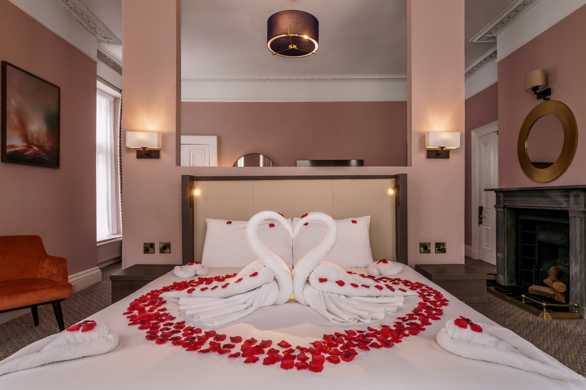 a bed with towels made of swans and rose petals