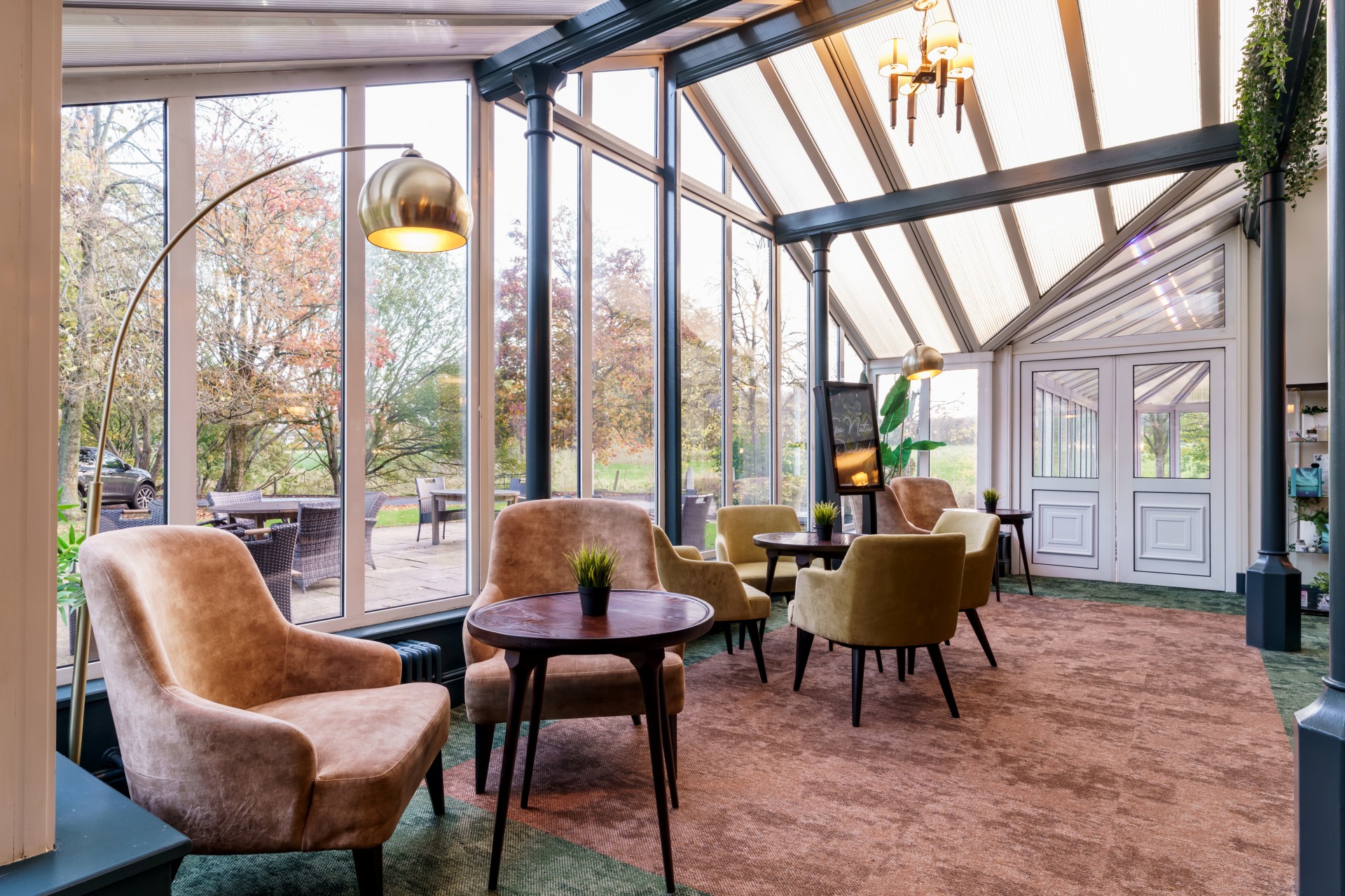 a room with a glass wall and chairs and a table