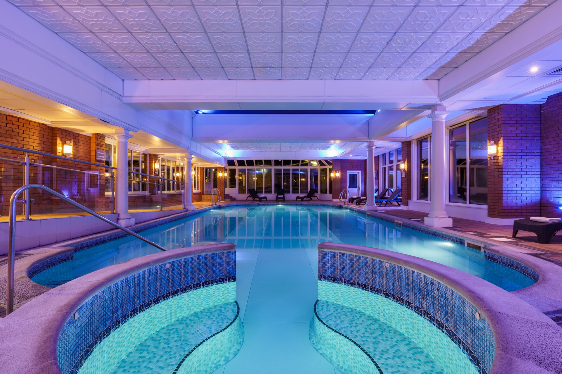a indoor swimming pool with a large tub