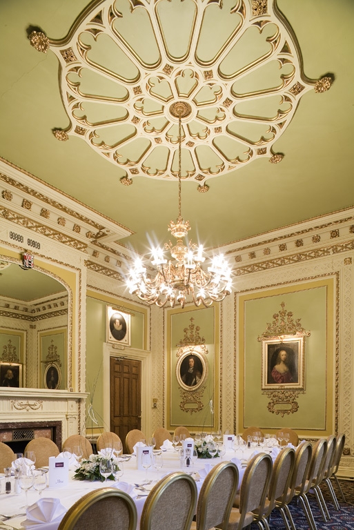 a room with a chandelier and a table set for a banquet