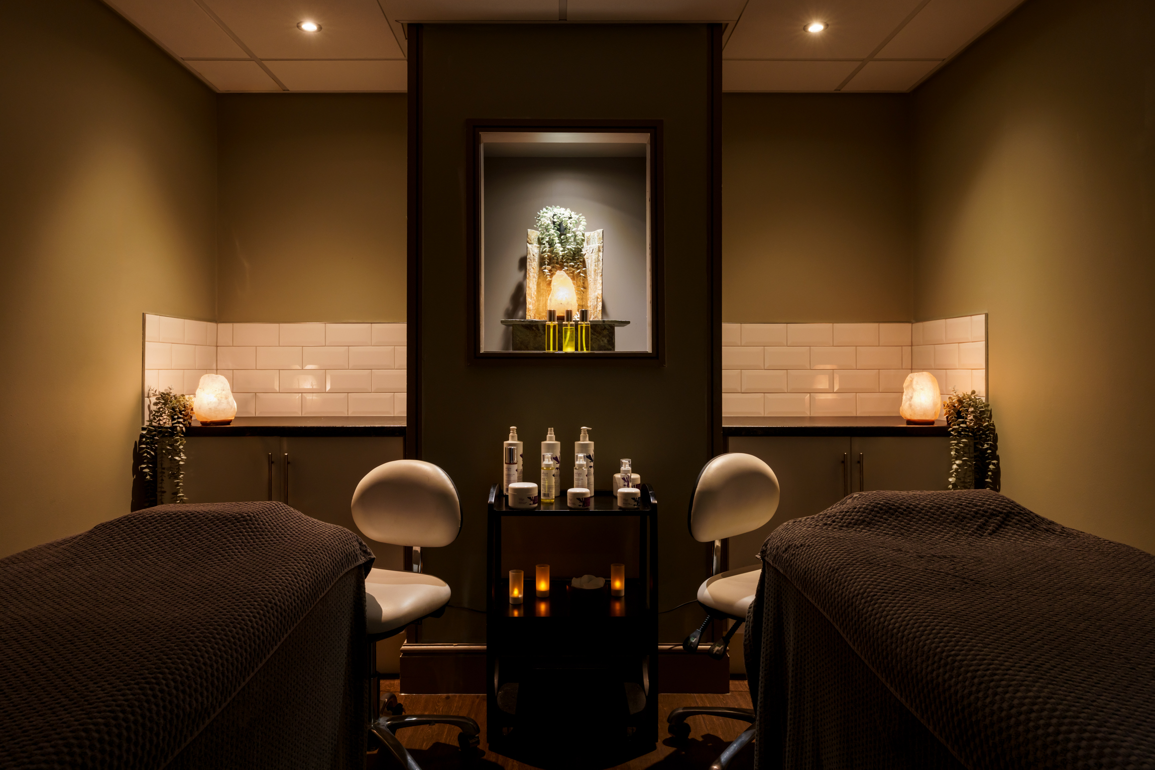 a room with two beds and a table with candles