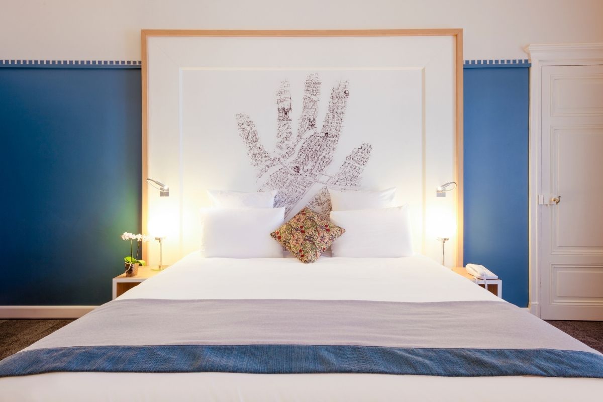 a bed with a large hand print on the wall