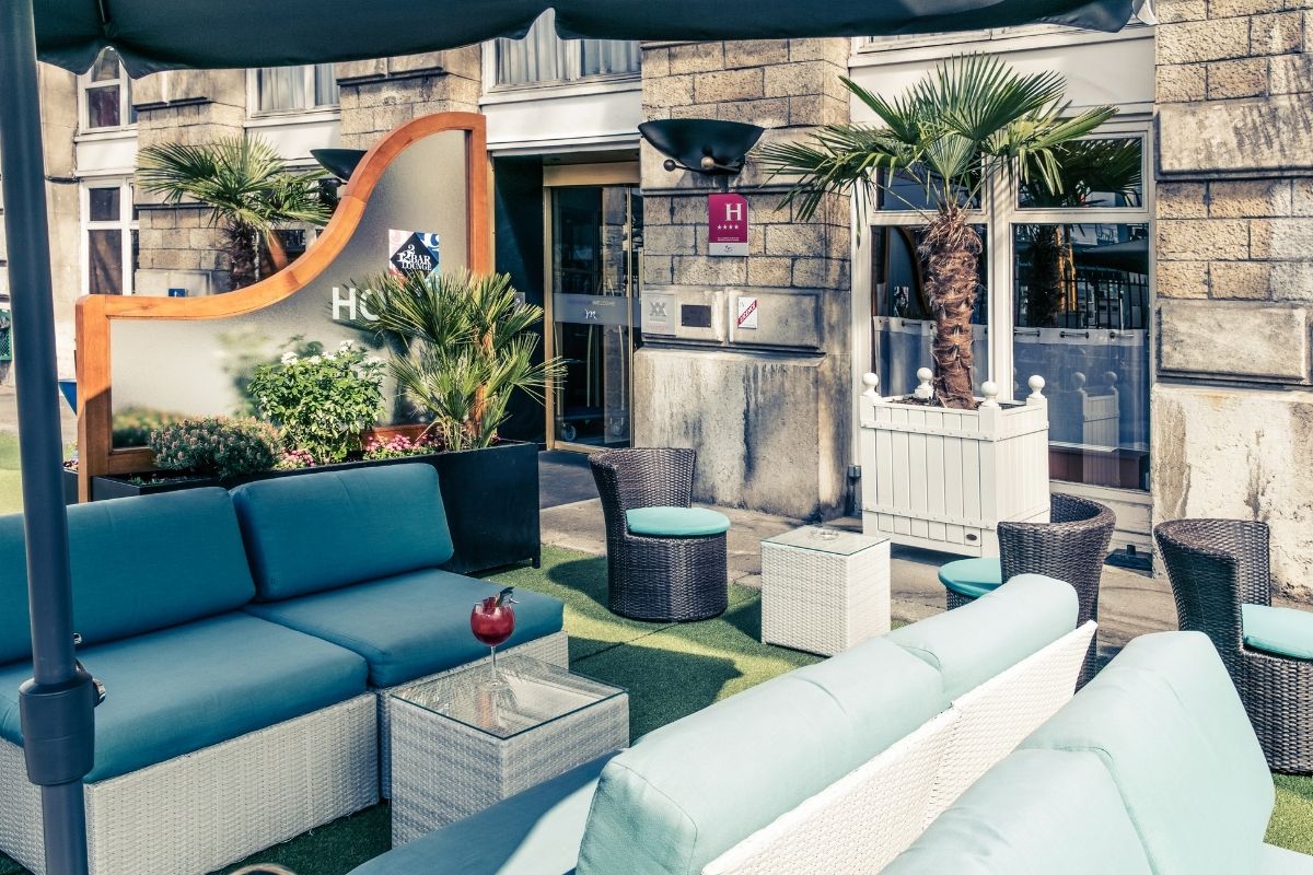 a patio area with furniture and palm trees