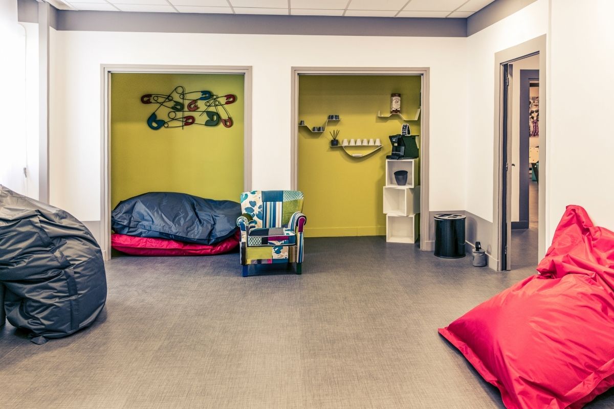 a room with a bed and chairs