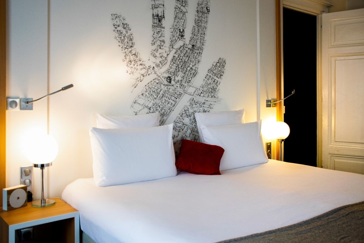a bed with white sheets and pillows
