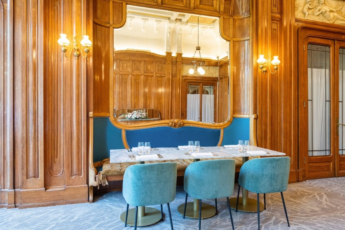 a table with blue chairs and a mirror in a room