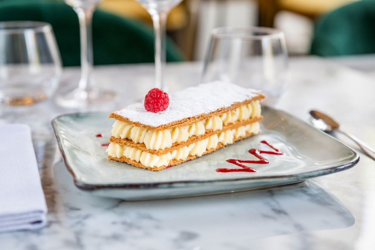 a plate of dessert with a raspberry on top