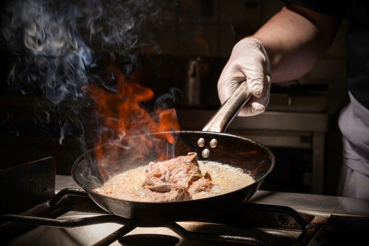 a person cooking food in a pan