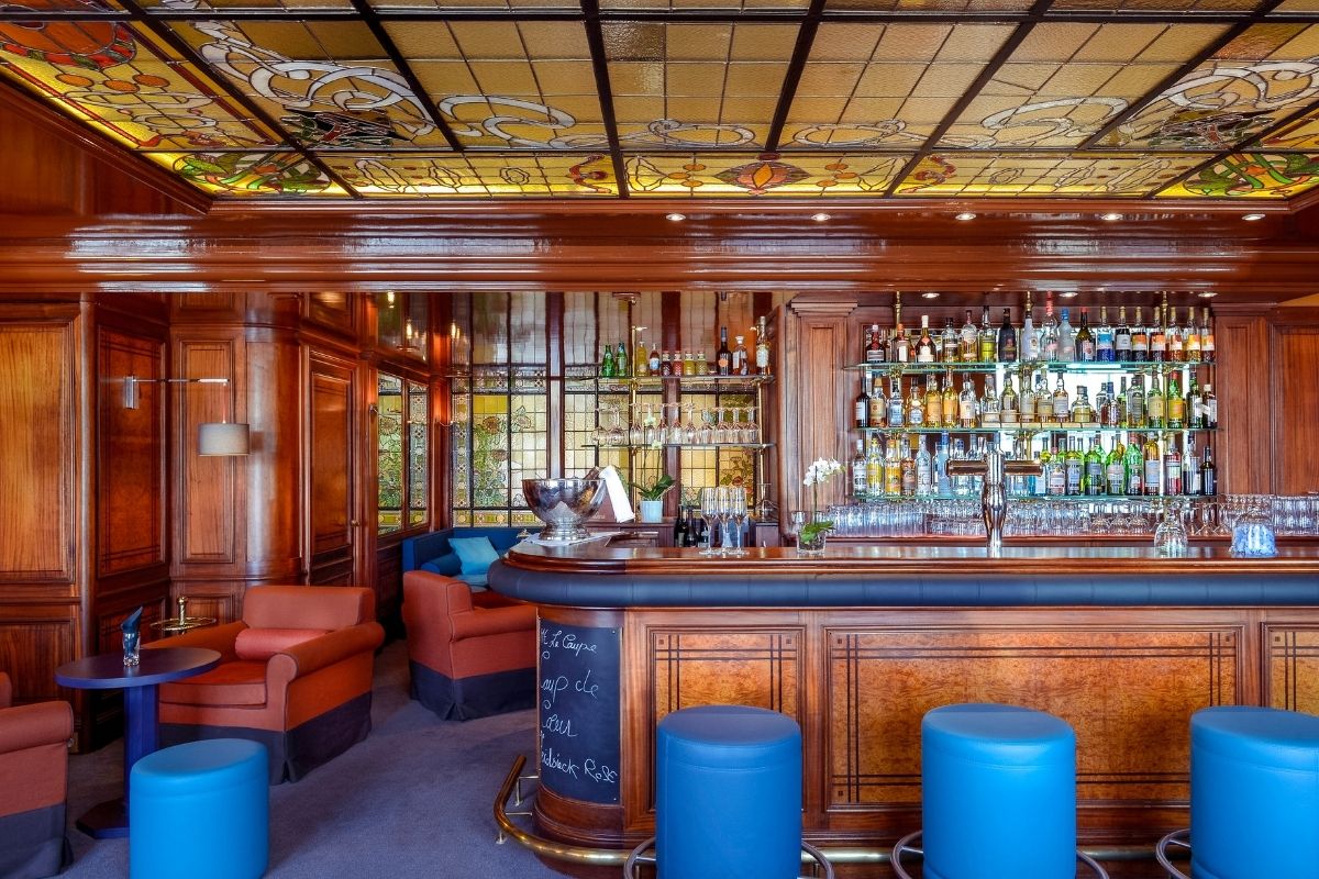 a bar with shelves of liquor and chairs