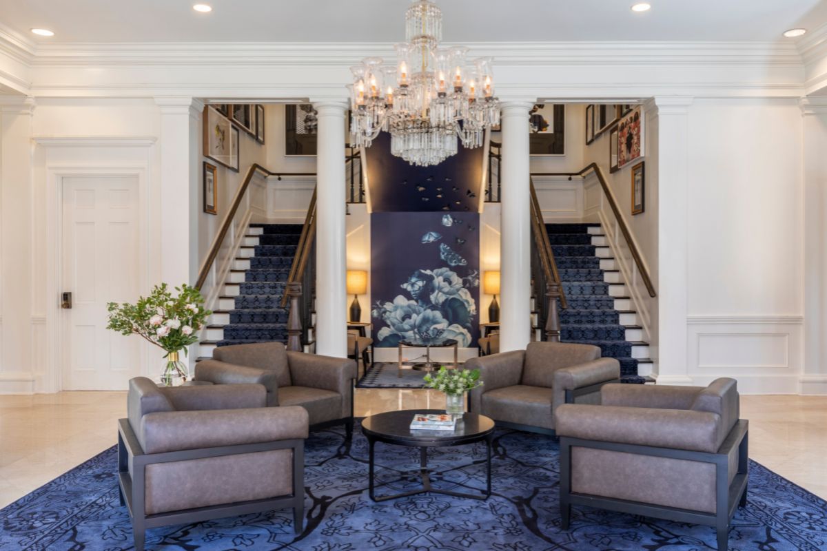 a lobby with chairs and a chandelier