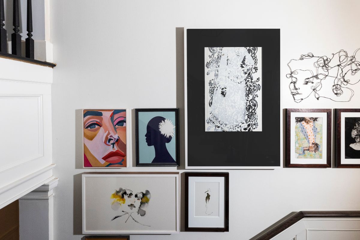 a wall with pictures and a staircase