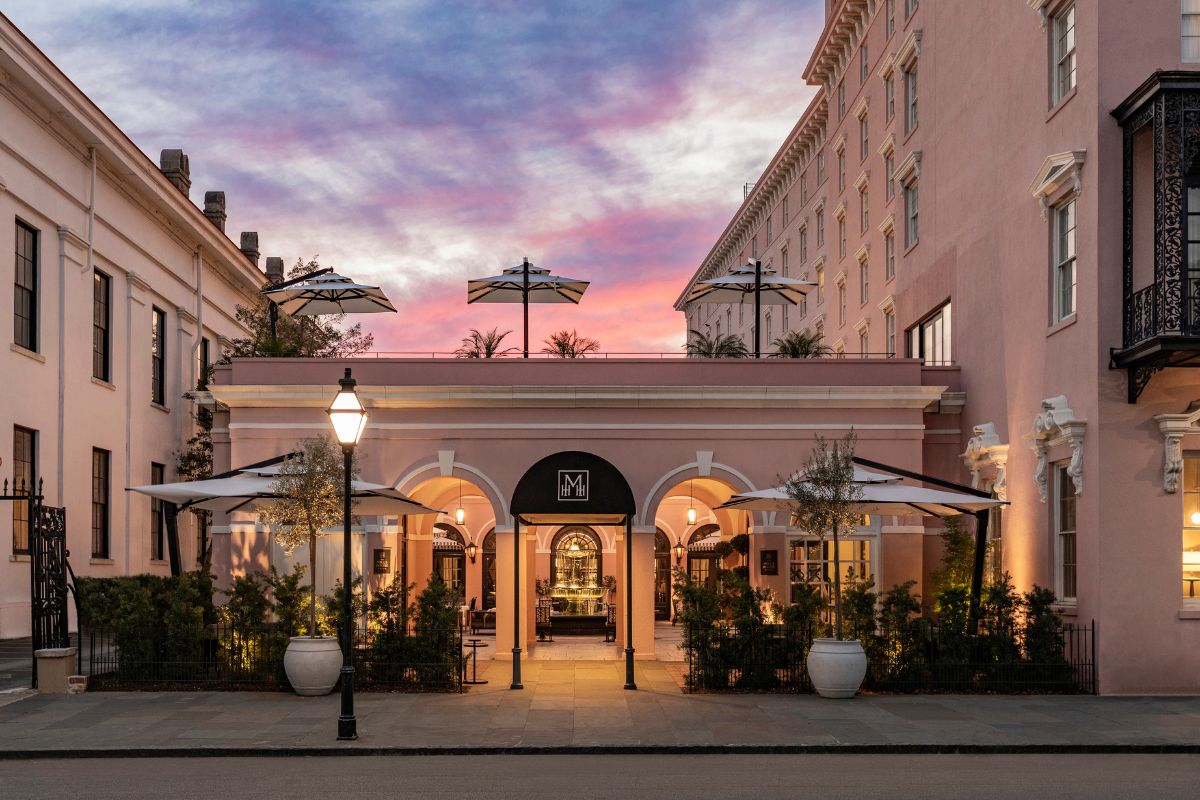 a building with a pink building with white columns and a pink sky