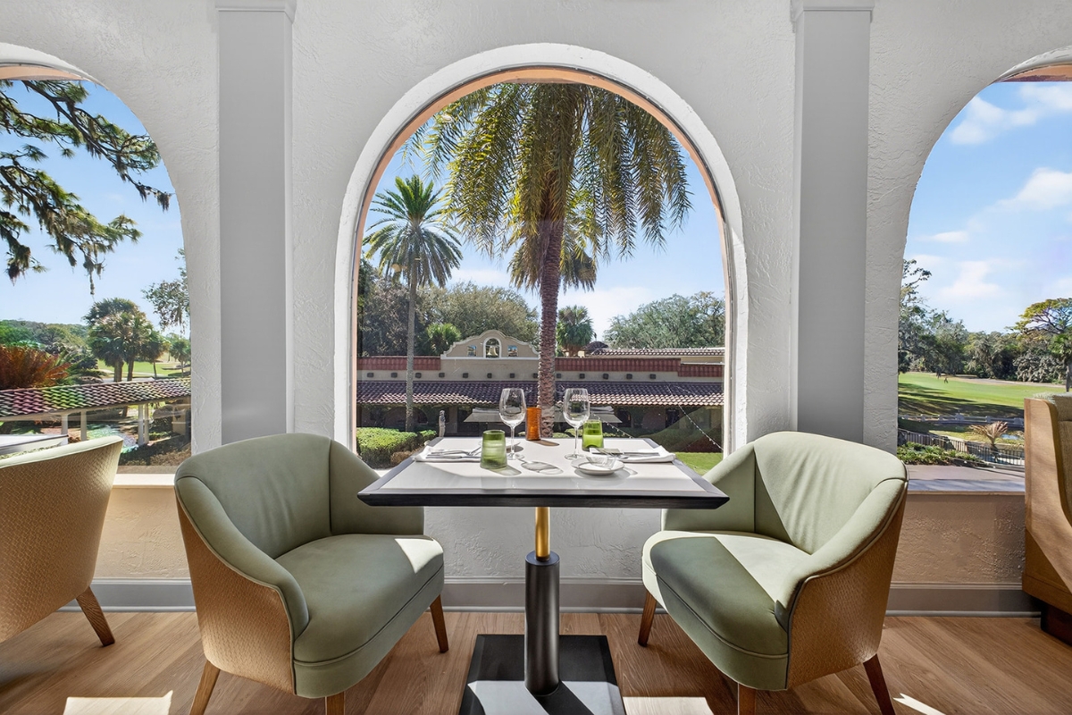 a table with glasses and plates on it and a table with two chairs