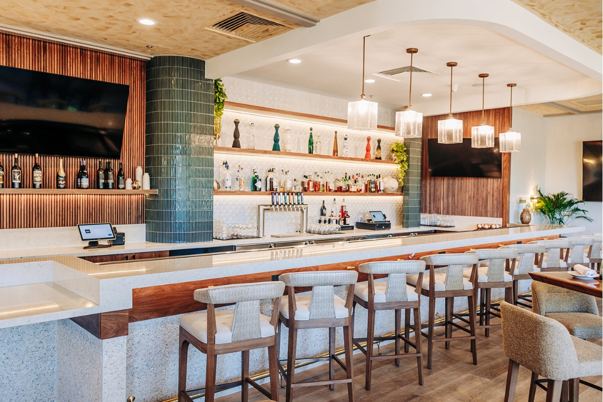 a bar with a row of chairs and a television