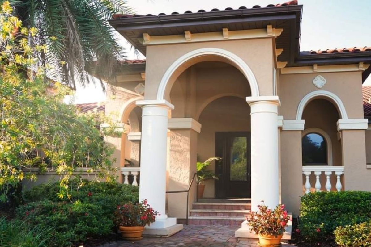 a house with columns and plants
