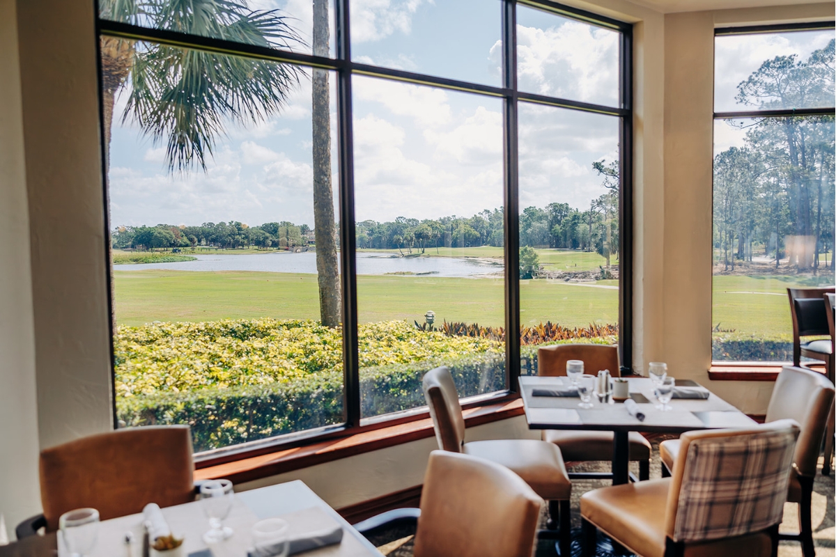 a room with a view of a golf course and a golf course through the windows