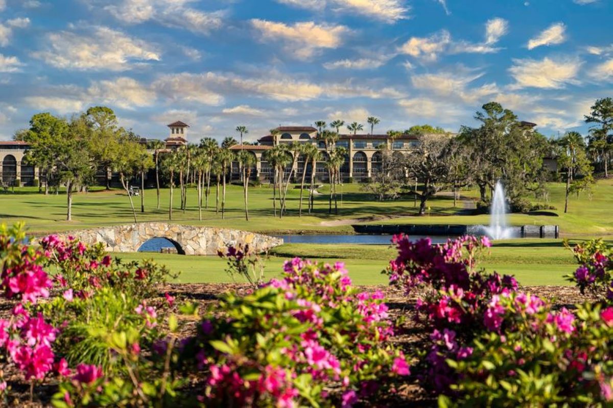a golf course with a building and a fountain