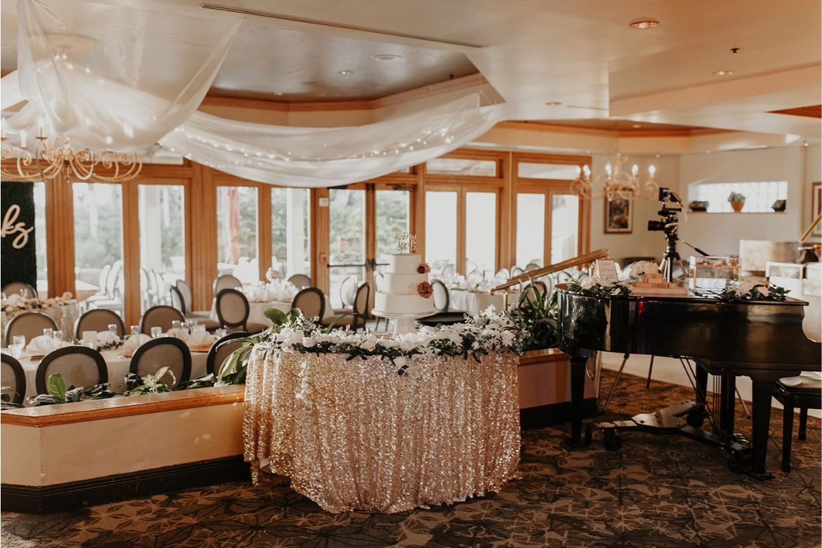 a wedding reception with a piano and a cake