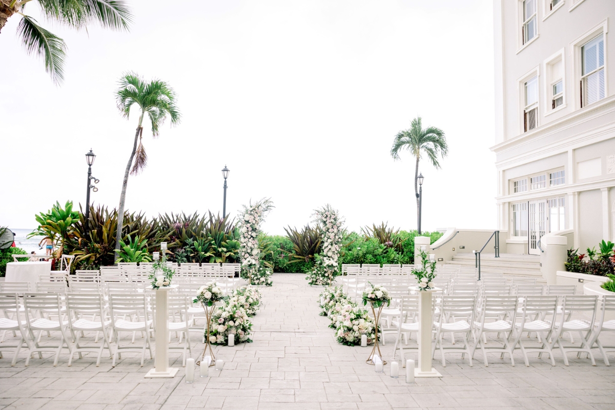 a white chairs and flowers on a walkway