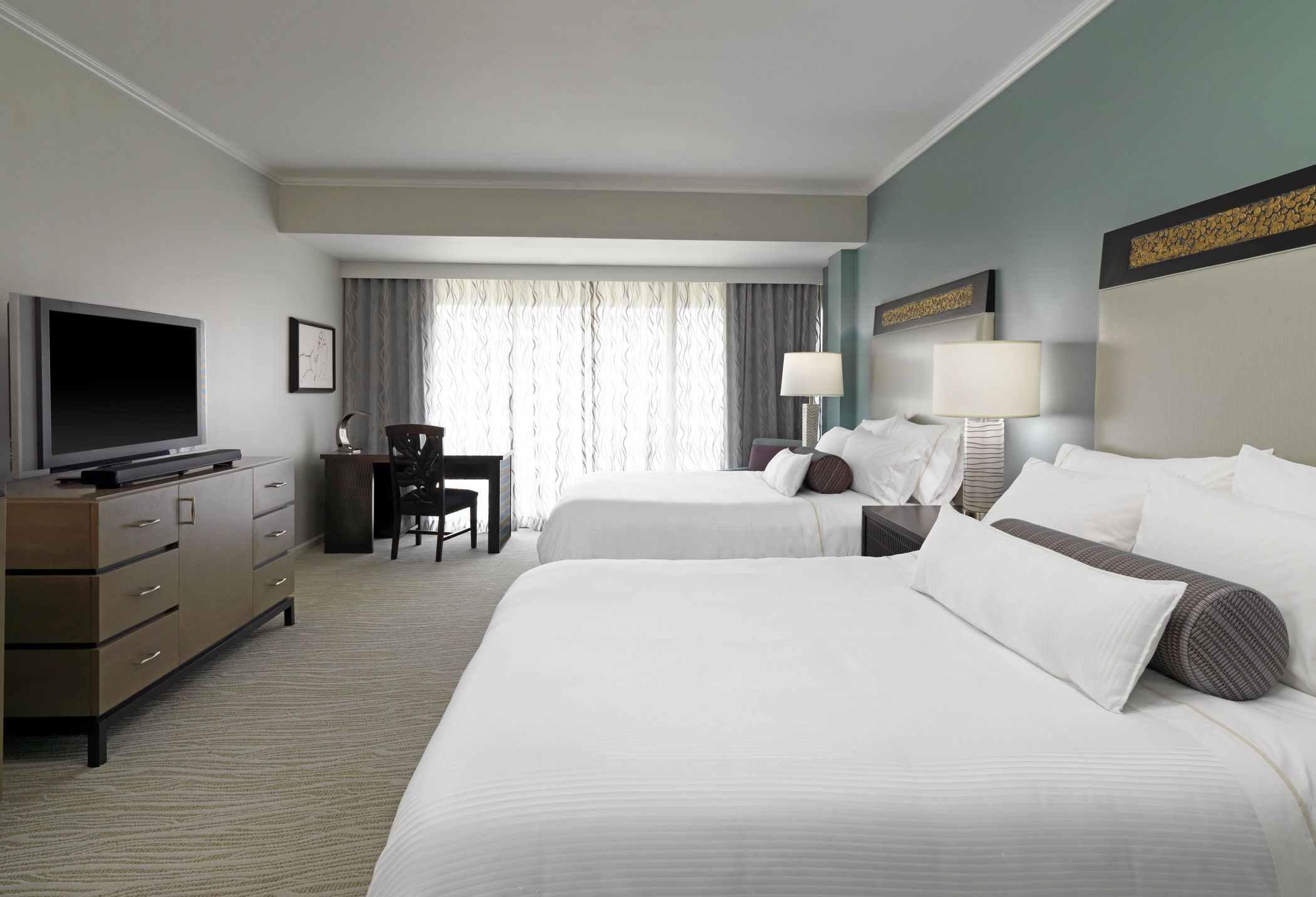 a room with two beds and a desk