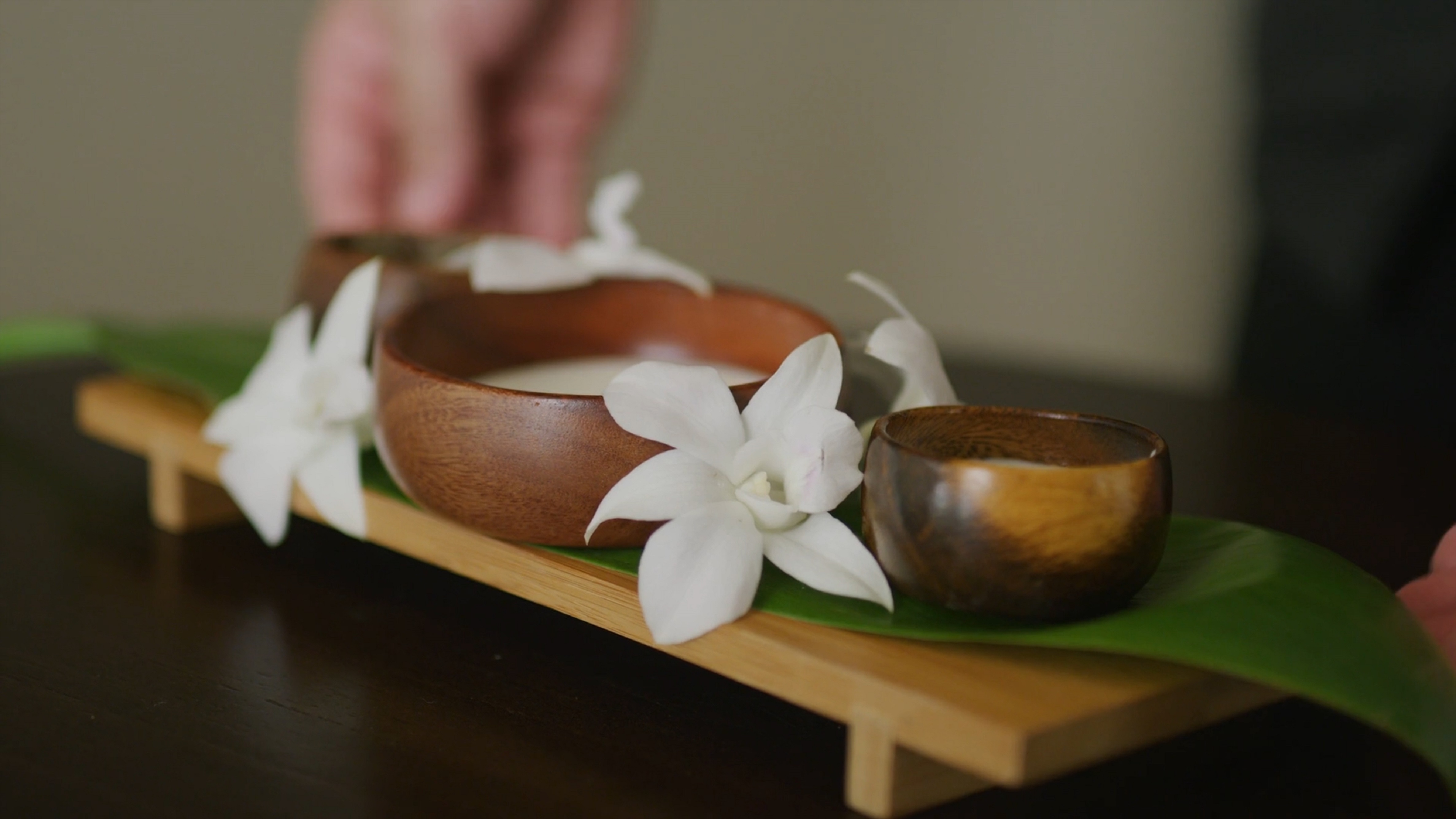 a bowl and bowl with white flowers on a leaf