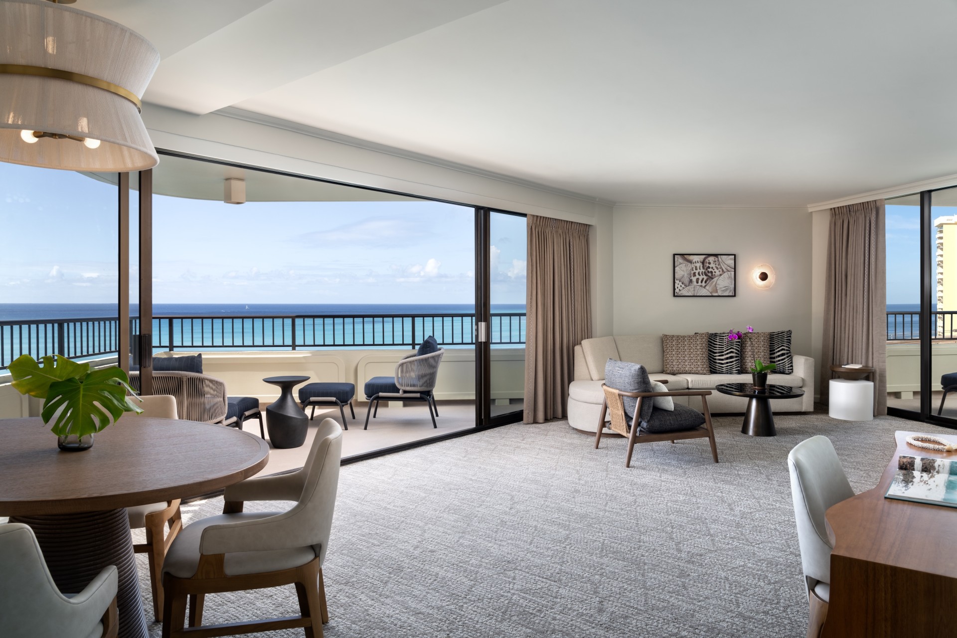 a living room with a balcony overlooking the ocean