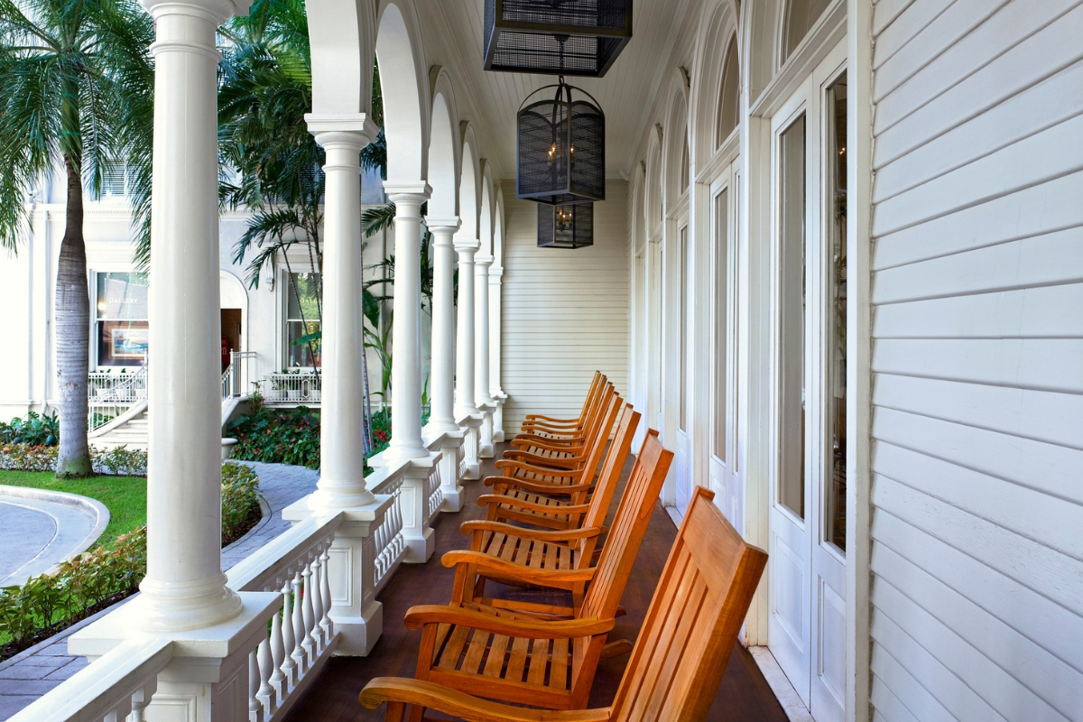 a row of wooden chairs on a porch