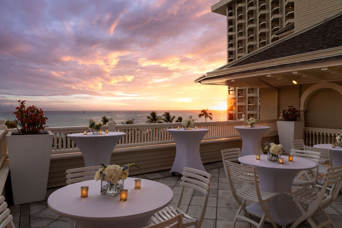 a patio with tables and chairs and a sunset