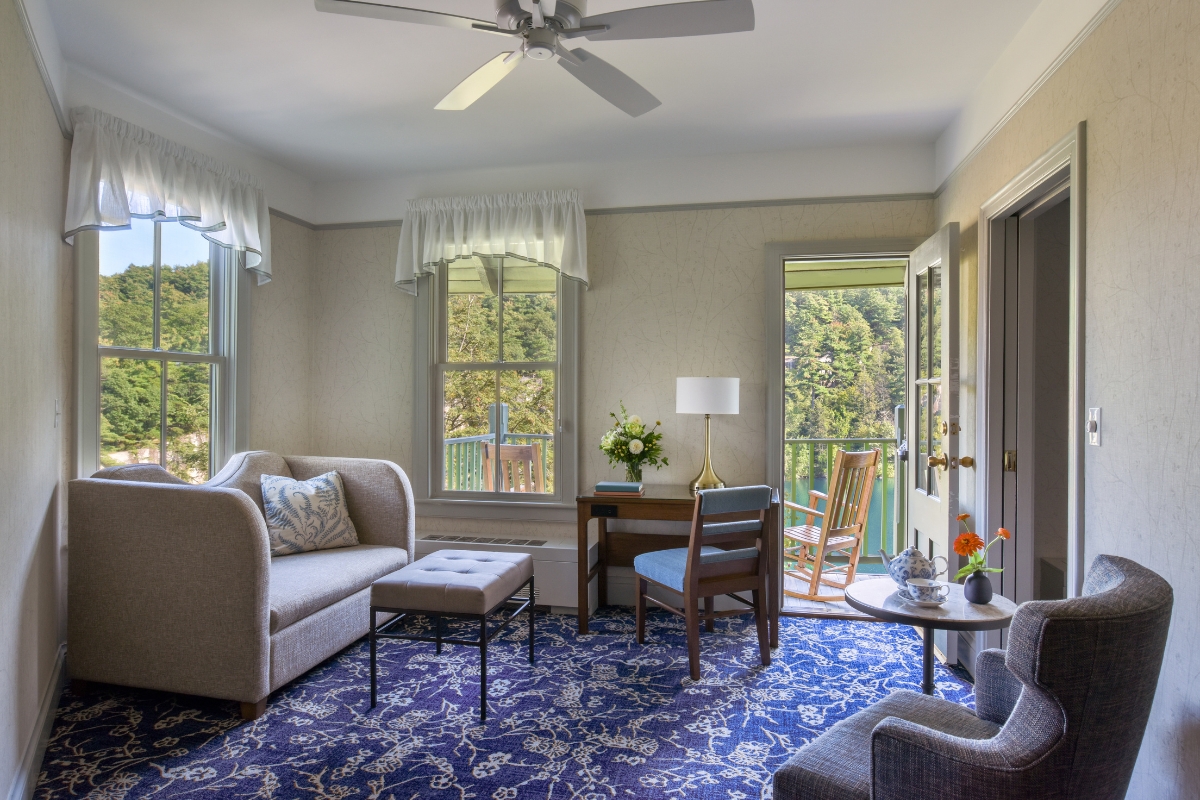 a living room with a blue rug and couches
