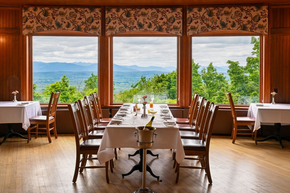 a table with glasses and a bottle of wine in front of a window