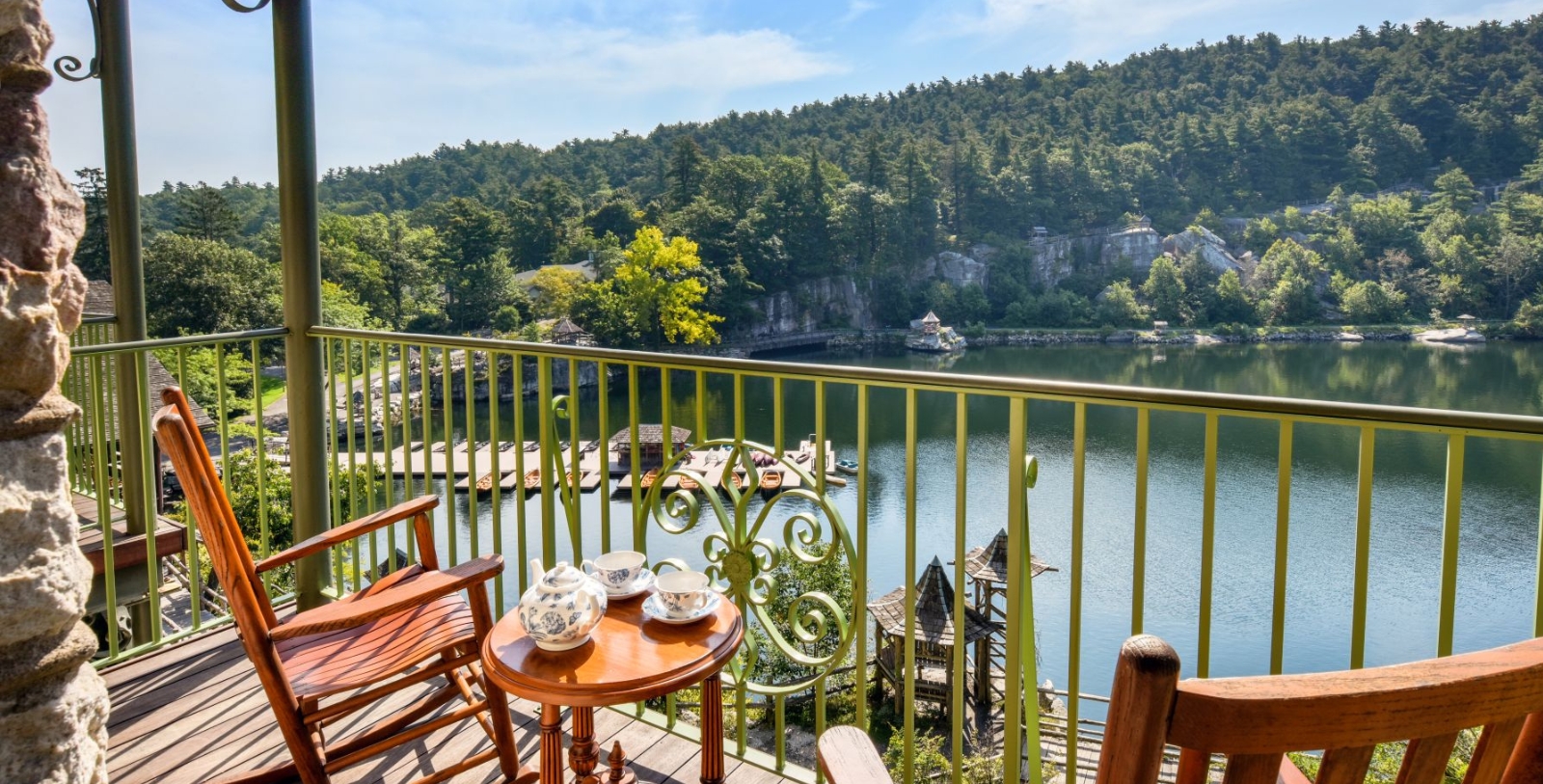 a table and chairs on a balcony overlooking a lake