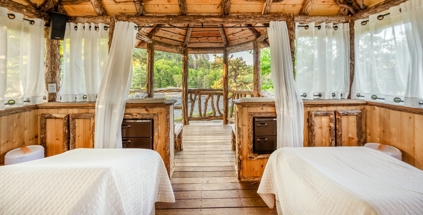 a room with white beds and wooden furniture