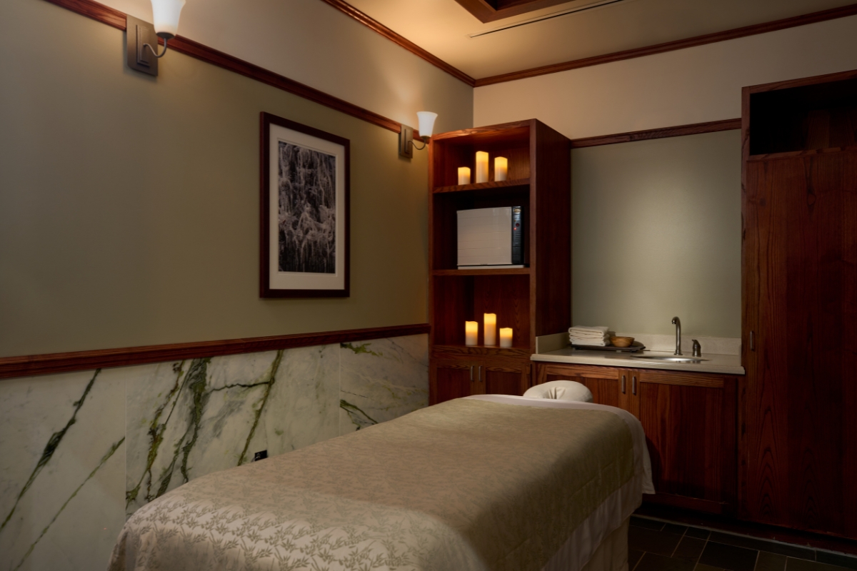 a massage room with a bed and shelves