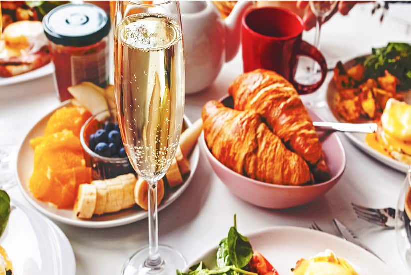 a glass of champagne next to food