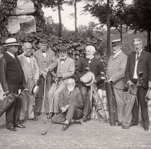 a group of men holding golf clubs