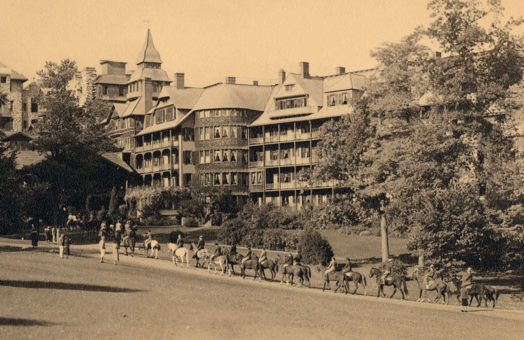 a group of people riding horses in front of a large building